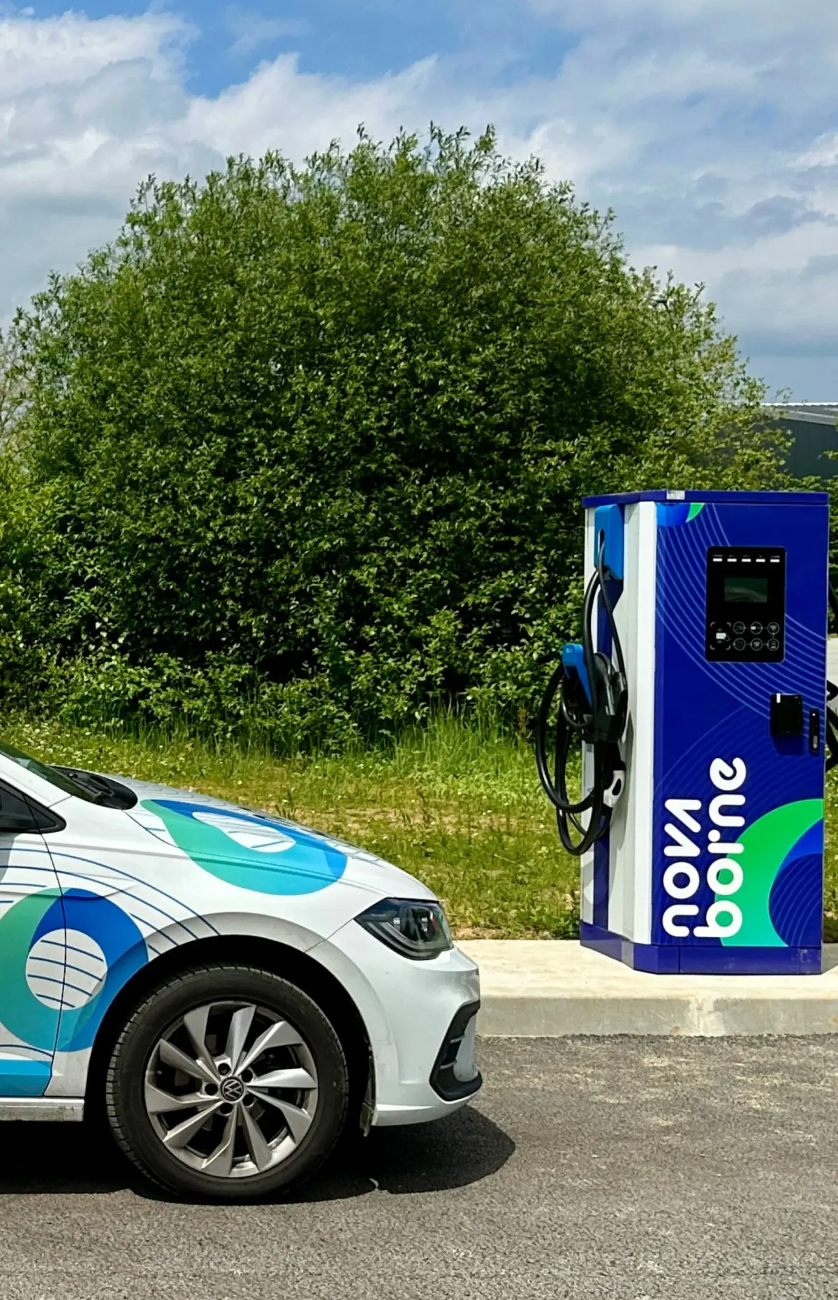 Borne de recharge installée à l'extérieur, à côté d'un véhicule en stationnement