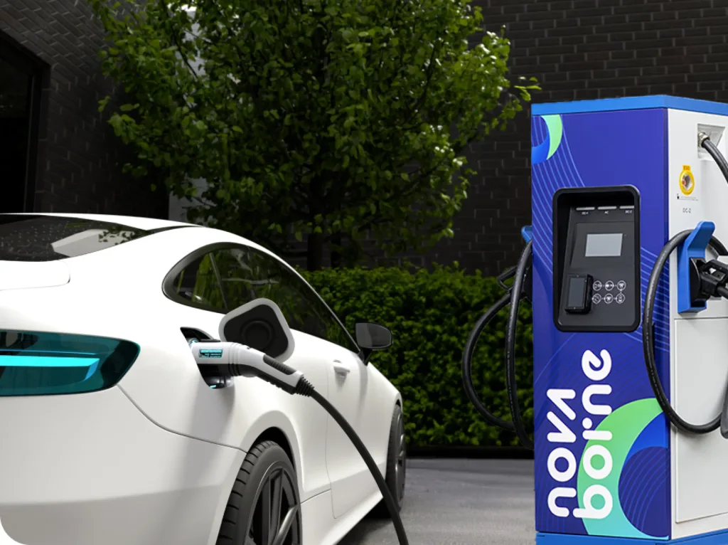 Véhicule électrique blanc en charge sur une borne installée devant un logement